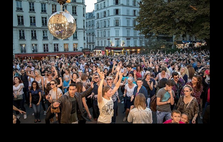 Lidé se baví a tančí v ulicích během festivalu  Fête des Vendanges de Montmartre.