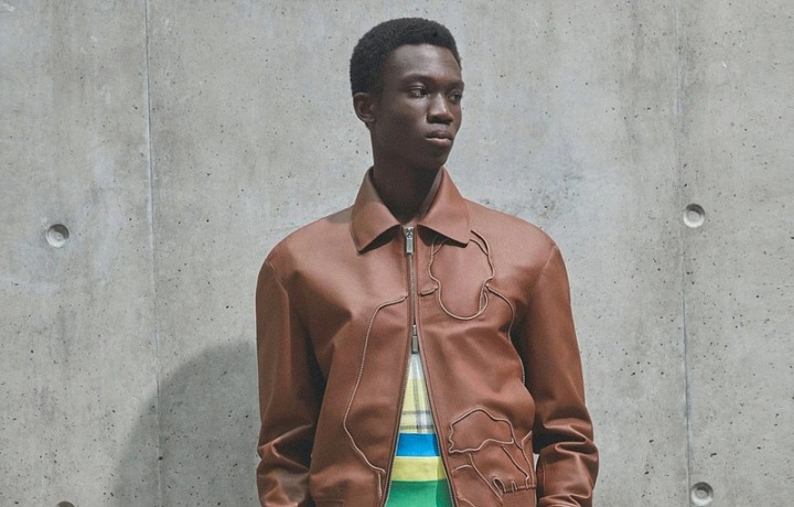 Muž v šortkách a kožené bundě Dior