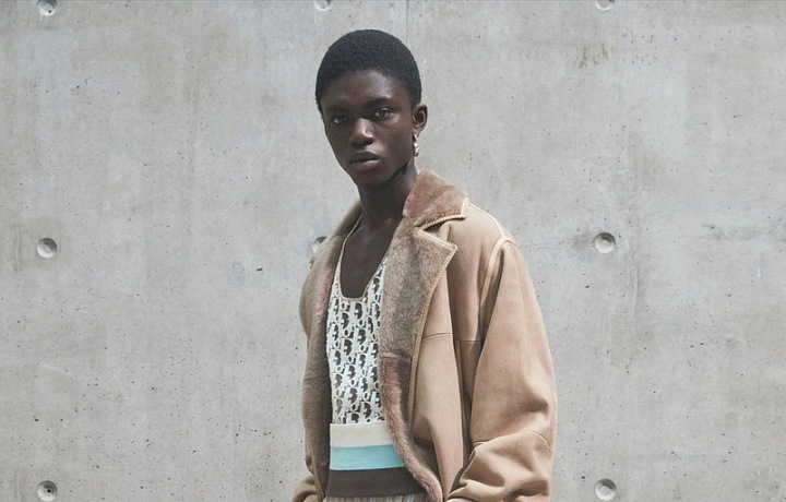 Muž v béžových kalhotách a béžovém kabátu Dior