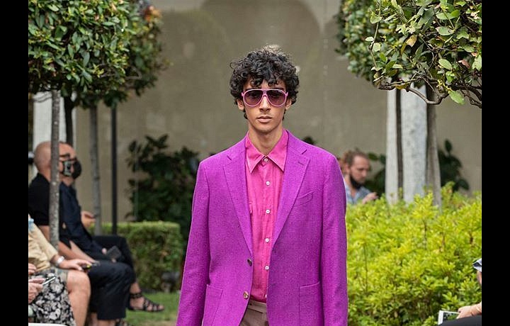 Muž v béžových kalhotách a neonovém saku Etro