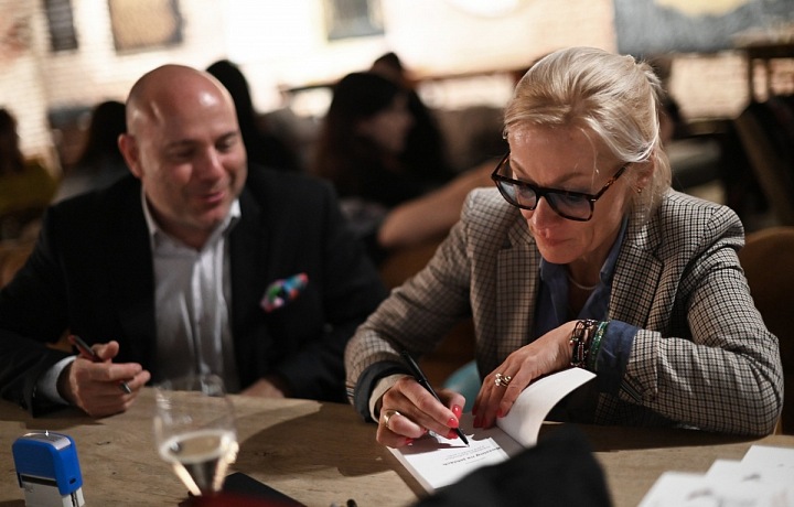 Julie podepisuje knížku.