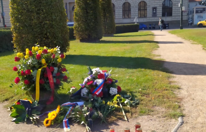 Před Rudolfinem lidé pokládají květiny a svíčky. 