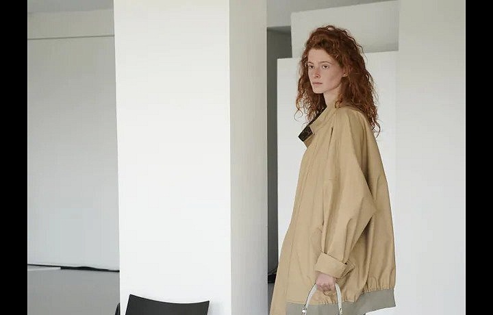 Žena v béžovém trenčkotu Louis Vuitton