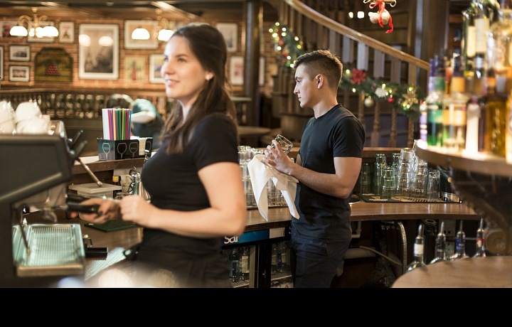 Muž a žena pracují za barem.