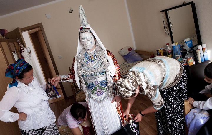 Na hlavu neveste položiaLíčení nevěsty kužeľovitú čiapku s červeným závojom