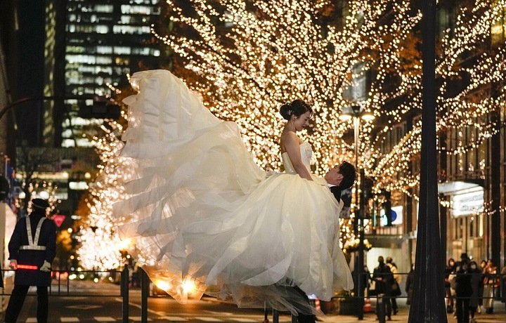 Lidé a páry, které se oddávají, si užívají vánočního osvětlení