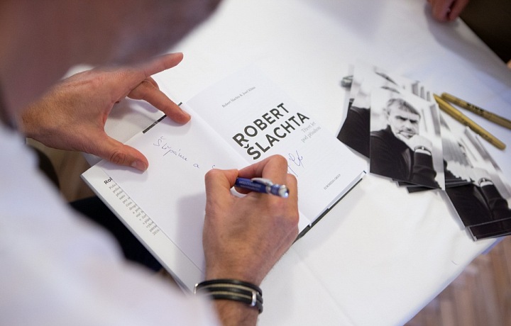 Robert Šlachta podepisuje svou knihu.