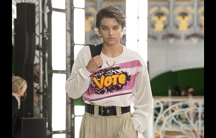 Žena v béžových kalhotách a bílém topu LV SS2021