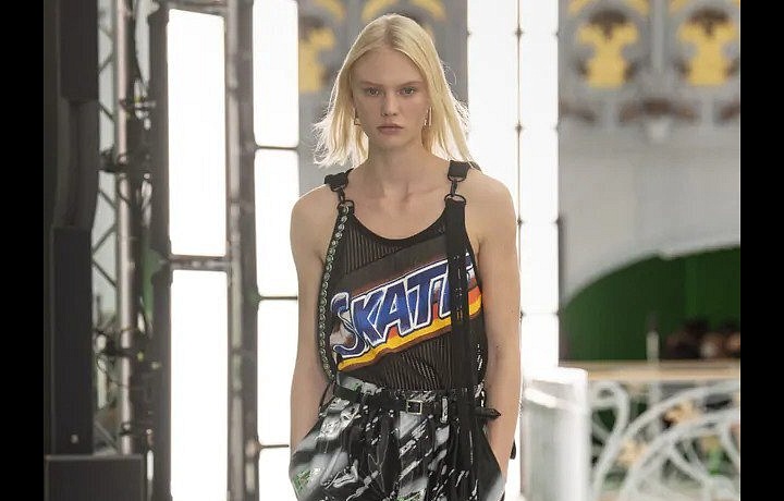 Žena v kalhotách a tílku s nápisem Skate