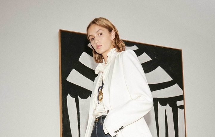 Žena v džínách a bílém saku Victoria Beckham