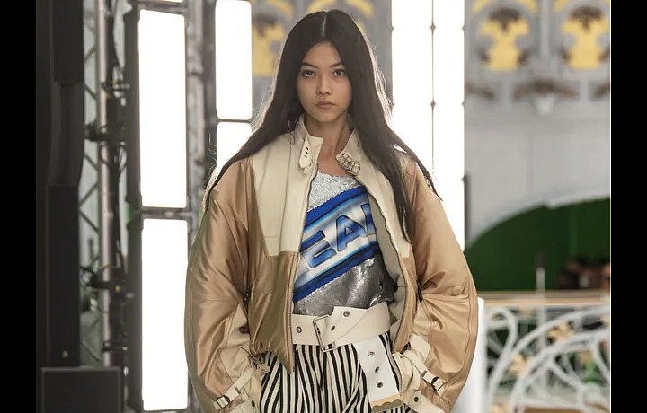 Žena v pruhovaných kalhotách a béžové bundě Louis Vuitton SS2021