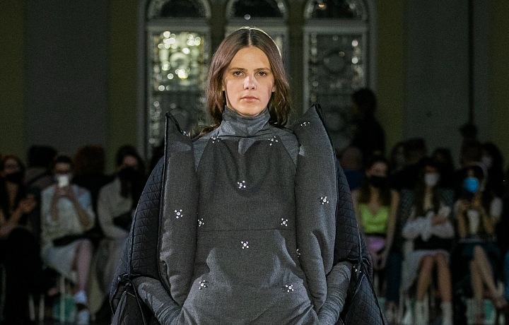 Žena v šedém outfitu s aplikací od Jakiba Polanky 