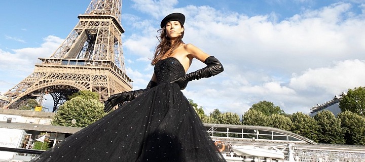 Žena v černých šatech Balmain pod Eiffelovou věží