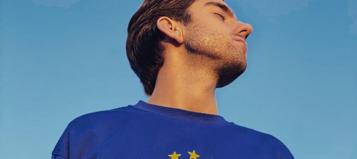 Muž se zavřenýma očima v mikině se symbolem EU.