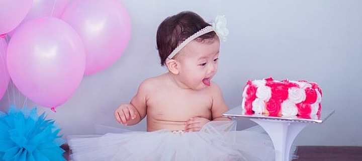 Miminko při oslavě narozenin s balonky a dortem. 