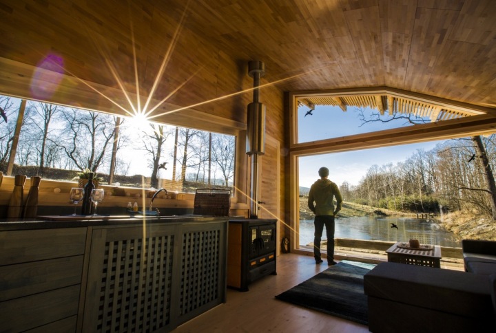 Naše země nabízí nepřeberně netradičního ubytování. Na foto muž dívající se z chatičky na hladinu rybníka