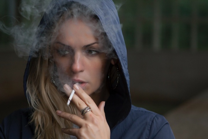 Žena, kouřící cigaretu Žena, kouřící cigaretu