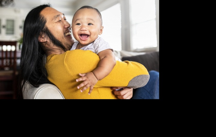 Rozesmátý muž držící dítě