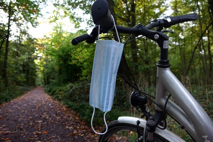 Rouška pověšená na řídítkách kola Rouška pověšená na řídítkách kola