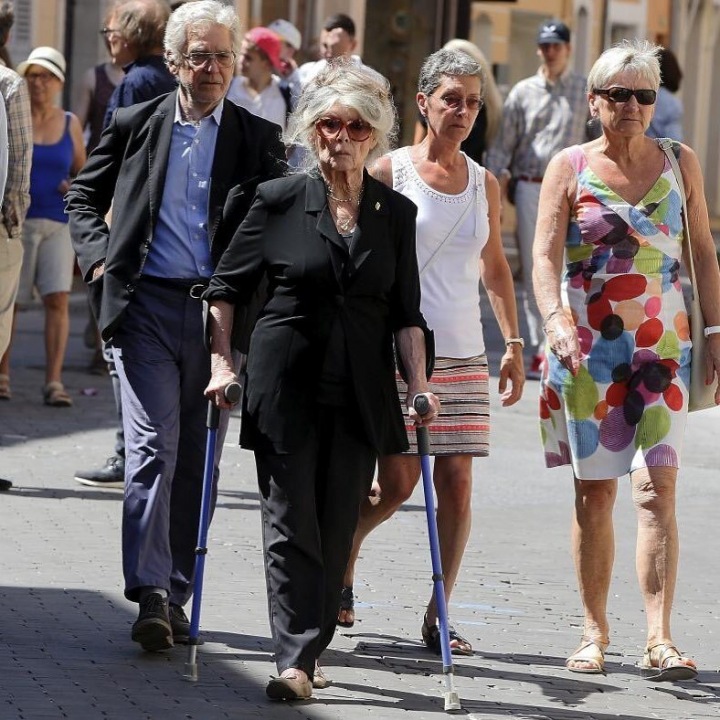 Brigitte Bardot na černobílém snímku na ulici s přáteli Brigitte Bardot na černobílém snímku na ulici s přáteli