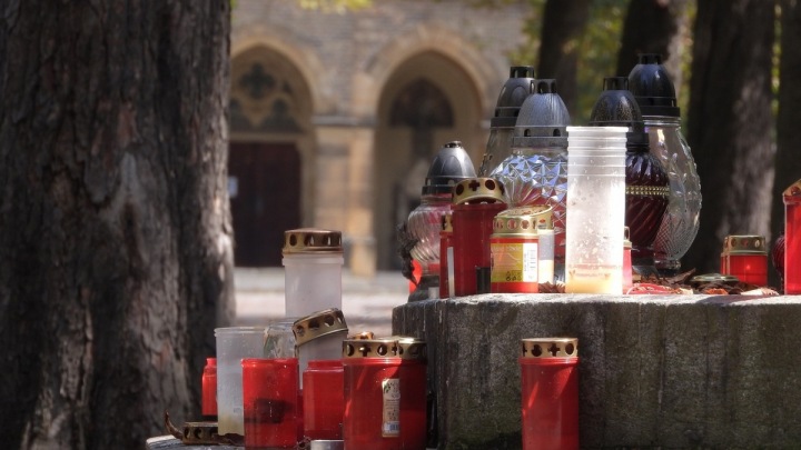 Na Dušičky lidé zdobí hroby a vzpomínají na své mrtvé. Svíčkami dekorovaný hrob.