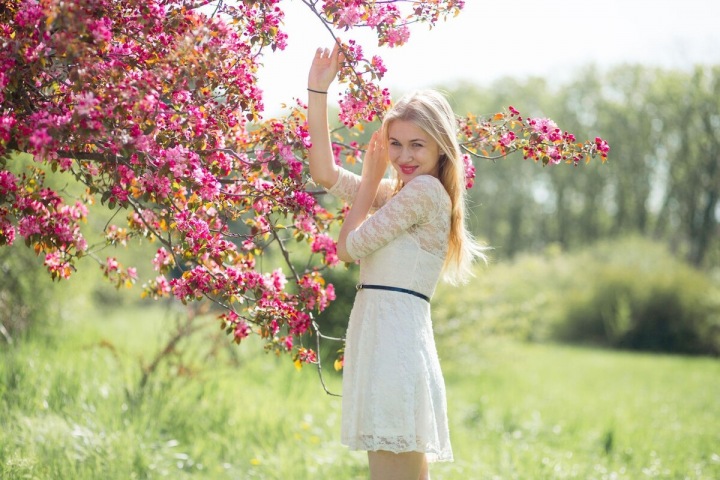 Žena pod rozkvetlým stromem.