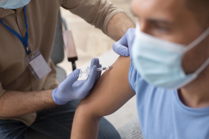 Doktor aplikuje pacientovi vakcínu