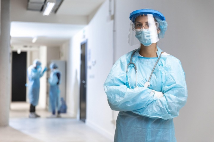 Doktorka v nemocnici s rouškou a štítem. Doktorka v nemocnici s rouškou a štítem.
