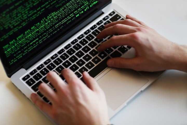 Muž hackuje počítač. 