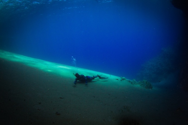 Freediver relaxující na dně.