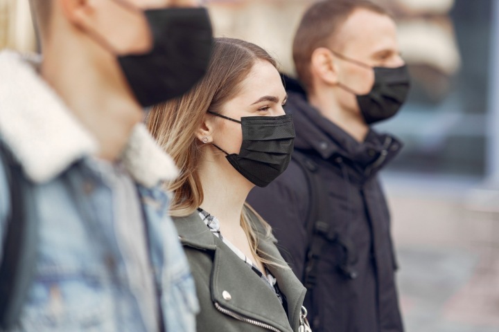 Lidé na ulici postávají v černých rouškách Lidé na ulici postávají v černých rouškách