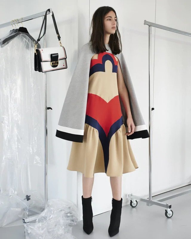 Žena v béžových šatech a šedé peleríně Louis Vuitton Žena v béžových šatech a šedé peleríně Louis Vuitton