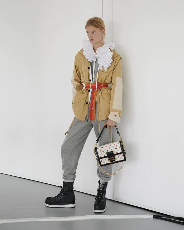 Žena v béžové bundě a šedých teplácích Louis Vuitton Žena v béžové bundě a šedých teplácích Louis Vuitton