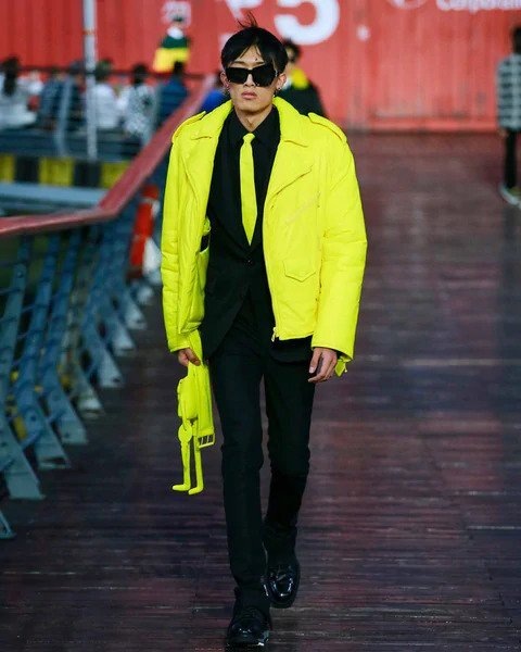 Muž v černém obleku a žluté bundě Louis Vuitton SS 2021 Muž v černém obleku a žluté bundě Louis Vuitton SS 2021