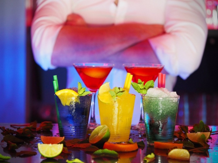 Míchané drinky a barman v pozadí. Míchané drinky a barman v pozadí.