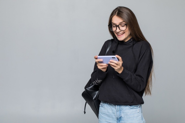 Mladá dívka si hraje na telefonu Mladá dívka si hraje na telefonu