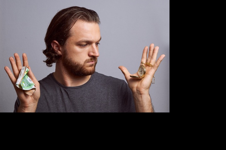 Muž s penězi a hodinkami.