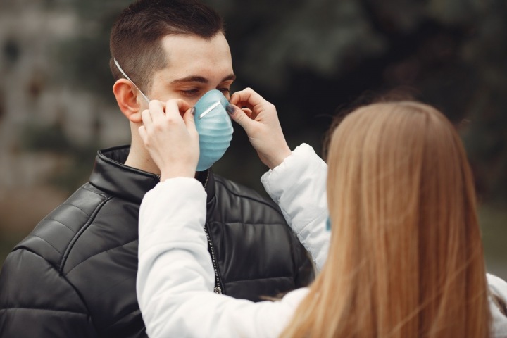 Dívka nasazuje chlapci respirátor Dívka nasazuje chlapci respirátor
