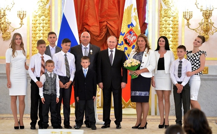 Vladimir Putin a Rita a Nikolaj Klimenkovi, nositelé Řádu slávy rodičů, se svými dětmi. Moskva, Kreml. 1. června 2015.