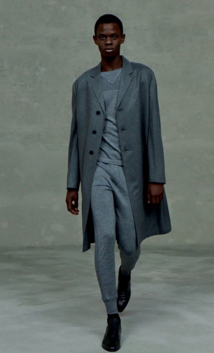 Muž v teplákách a šedém kabátu Prada