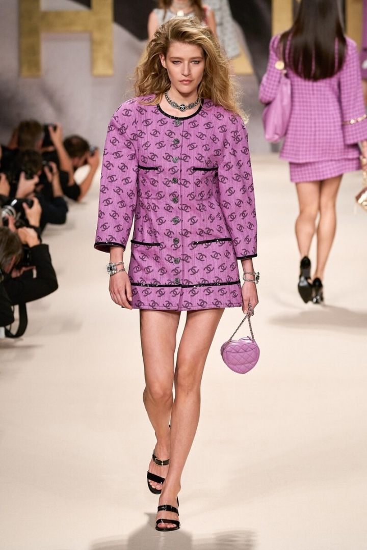 Modelka ve starorůžových šatech. Potisk loga nás vrátil do roku 1989.