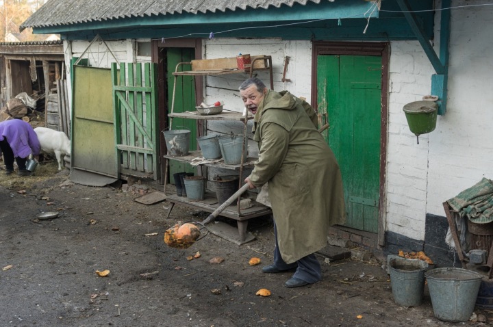 Ukrajinský venkovan uklízí před domem.