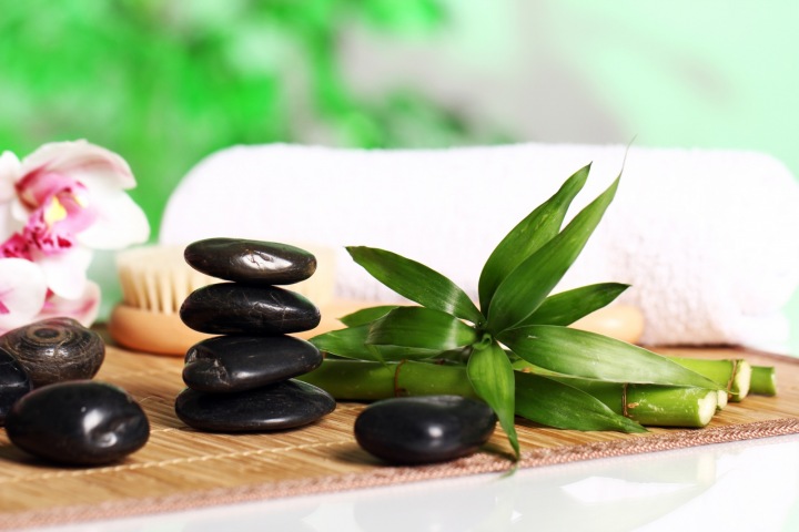 Alternativní medicína je často skvělým doplňkem léčby. Kameny, bylinky a ručník.