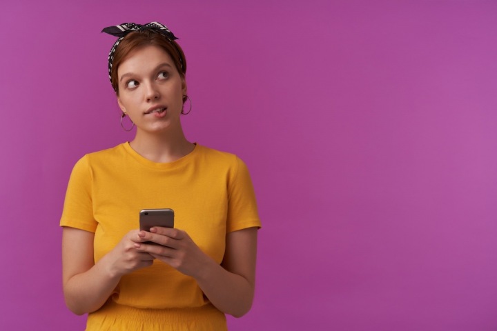 Zamyšlená dívka s mobilem v ruce Zamyšlená dívka s mobilem v ruce