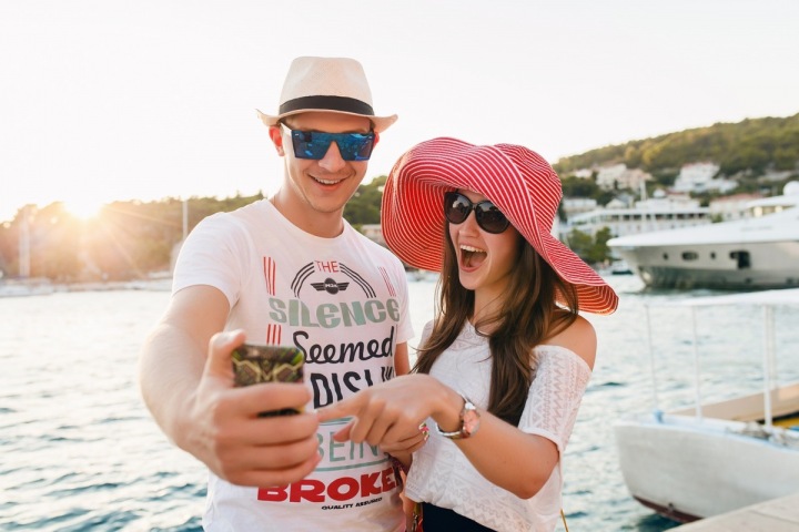 Pár užívající si dovolenou, usmívající se pro selfie Pár užívající si dovolenou, usmívající se pro selfie