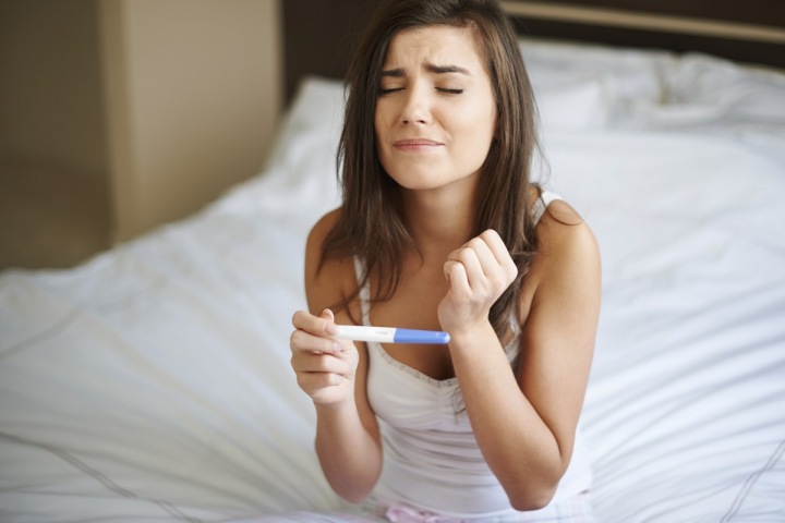 Žena čeká na výsledek těhotenského testu. Žena čeká na výsledek těhotenského testu.