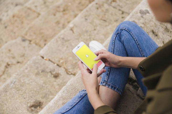 Žena se připojuje k mobilní aplikaci Snapchat Žena se připojuje k mobilní aplikaci Snapchat