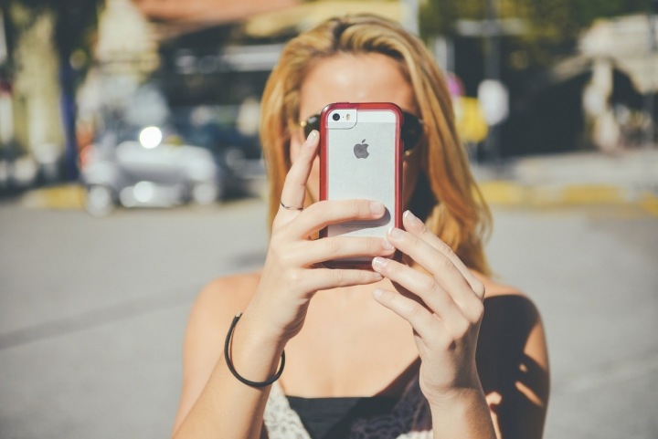 Žena s iPhonem v rukou Žena s iPhonem v rukou