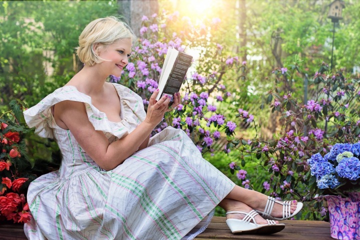 Žena si na zahradě čte