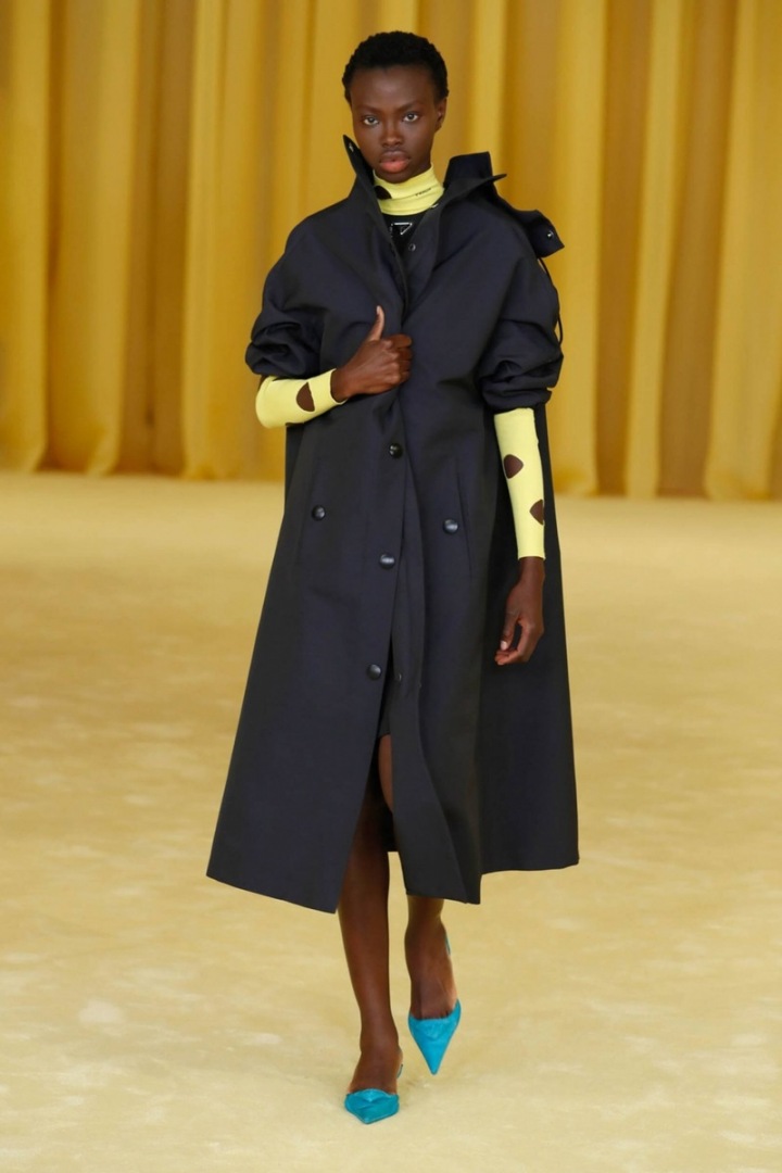 Žena v černém kabátu Prada SS2021 Žena v černém kabátu Prada SS2021